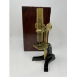 A 19th century brass microscope, with various slides, in mahogany case, 24 cm high