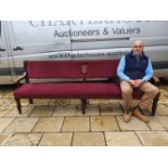 A mahogany settle, with upholstered back and seat, back inset with plaque for the Royal British