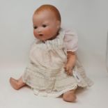 An Armand Marseille bisque head doll, with sleeping eyes, two exposed teeth and molded hair,