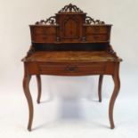 A late 19th century walnut ladies writing desk, having a superstructure, with a single cupboard