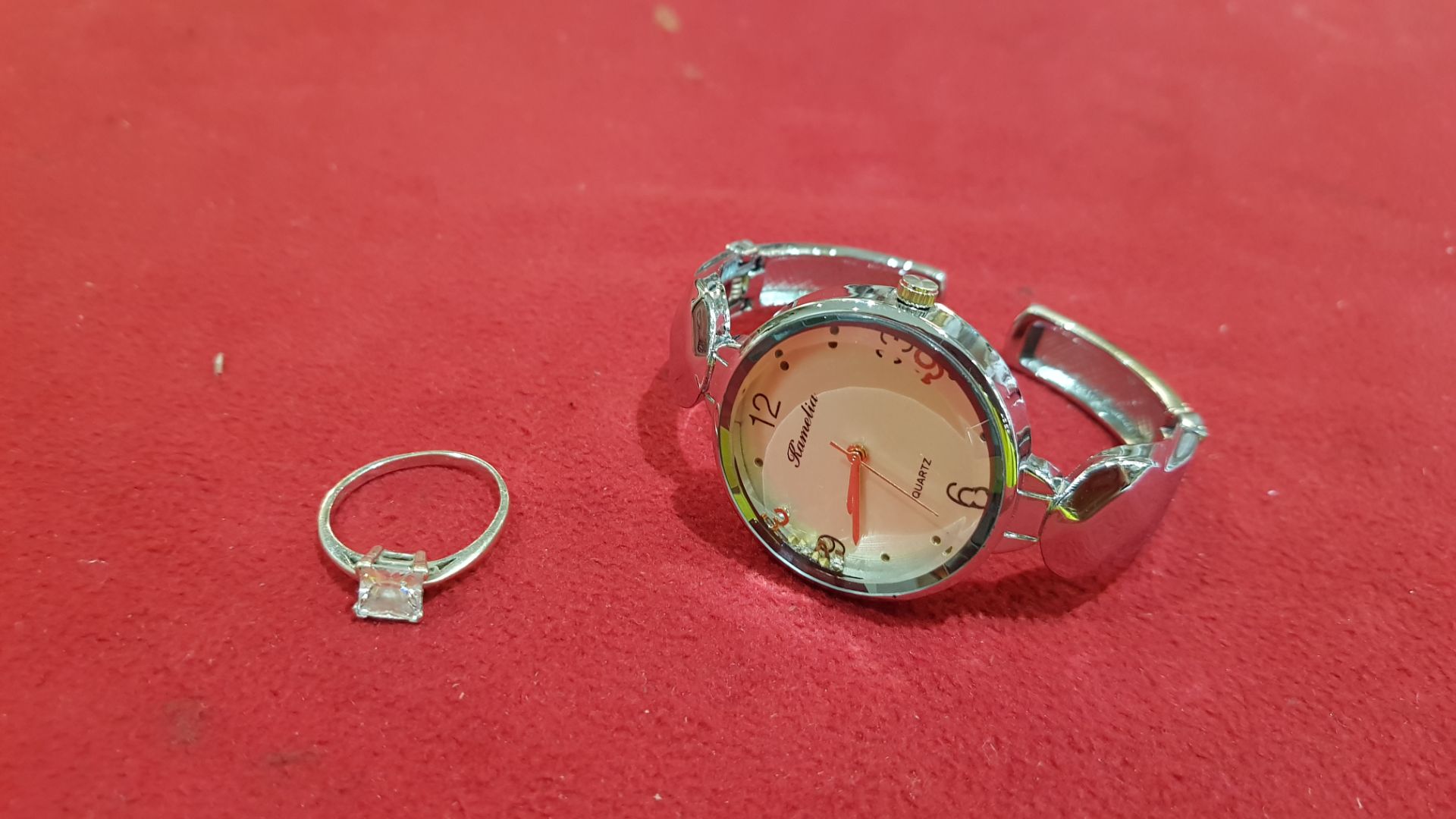 2 PIECE ASSORTED LOT CONTAINING 1 X WATCH BRANDED RAMELIA AND 1 X SILVER COLOURED RING WITH CLEAR