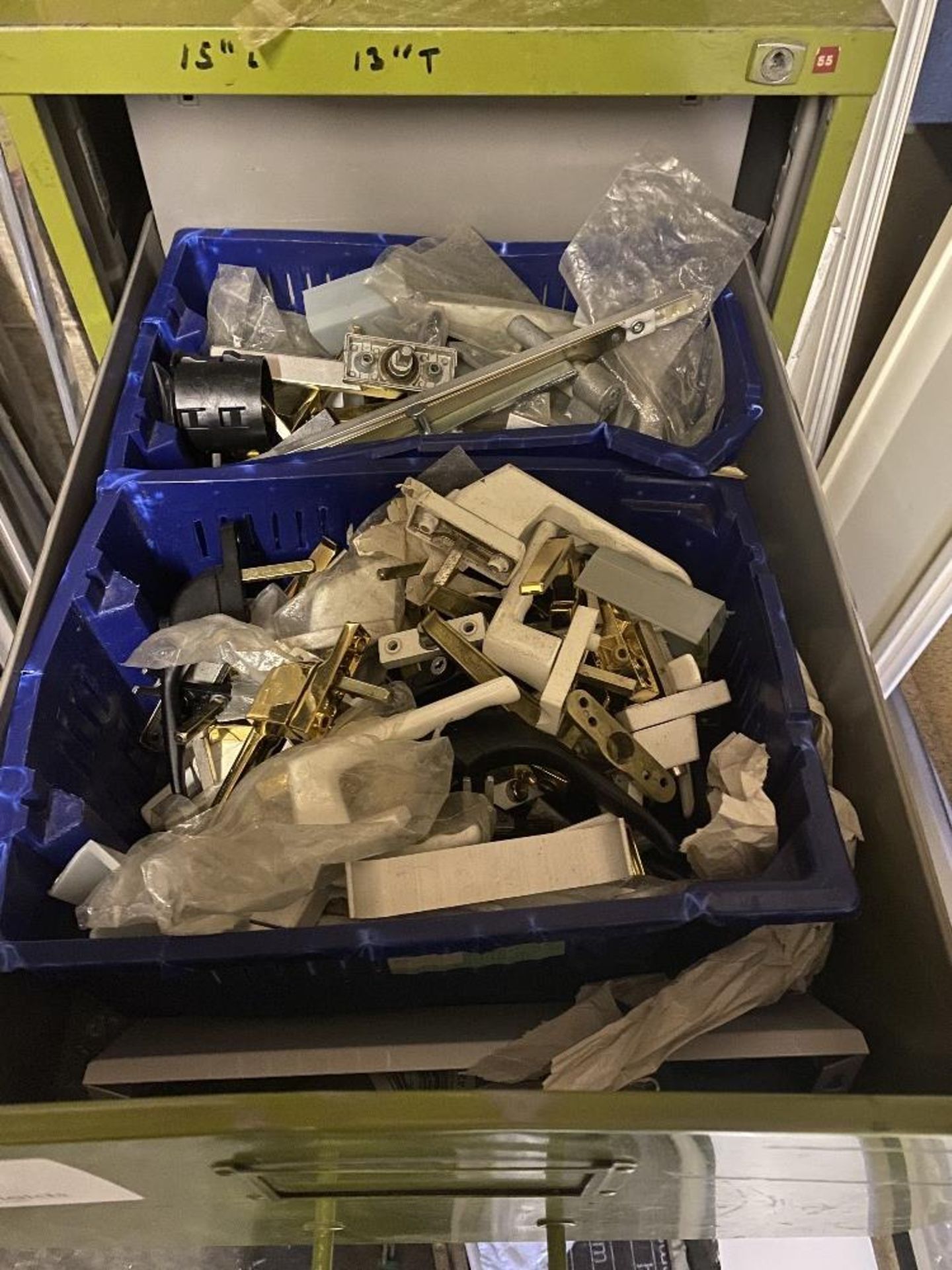 Four drawer metal filing cabinet comprising various door handles