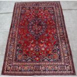 A Persian Mashad woollen hand knotted carpet with central floral medallion within floral borders