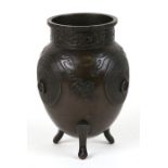 A Japanese bronze vase with three ring handles and panels of calligraphy, on three legs, 20cms (