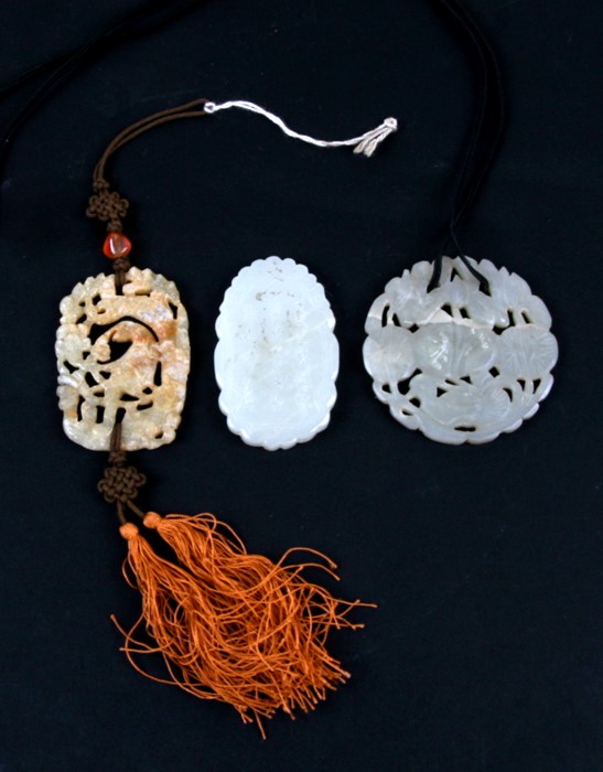 Three Chinese pierced jade pendants, the largest 6.5cms (2.5ins) high.