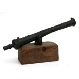 A bronze cannon with a 38cm (15ins) barrel on a wooden plinth.