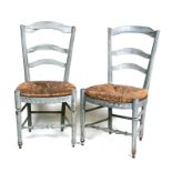 A pair of French style painted ladderback dining chairs with rush seats (2).