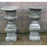 A pair of concrete urns of classical form, on plinth bases, each 105cms (41ins) high (2).