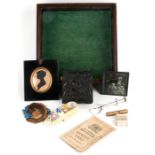 A mahogany glazed table top display case, 26cms (10ins) wide, containing a silhouette portrait