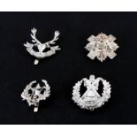 Four silver plated Military cap badges: The Queens Own Cameron Highlanders, The Cameronians (