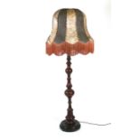 A continental turned walnut standard lamp with vellum shade.