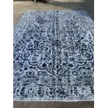 A Persian woollen carpet, shaved and re-dyed, with foliate blue & navy scrolls on a white ground,