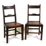 A pair of George III mahogany dining chairs with solid seats, on square tapering legs joined by