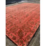 A Persian woollen carpet, shaved and re-dyed, with deep red foliate scrolls on a lighter red ground,