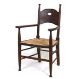 A William Birch for Liberty Arts & Crafts oak armchair with rush seat and ring turned front supports