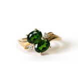 A 9ct gold ring set with two oval green stones and six small diamonds, approx UK size 'J', 2.6g.