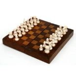 A carved bone chess set in a mahogany case, 30cms (12ins) wide.Condition Reportwhite pieces - all