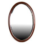 An Edwardian mahogany oval wall mirror, 89cms (35ins) wide;