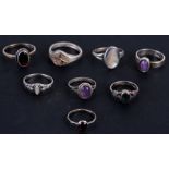 A group of eight silver dress rings.