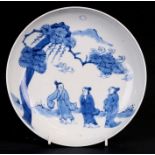 A Chinese blue & white shallow dish decorated with three figures standing under a tree, 19cms (7.