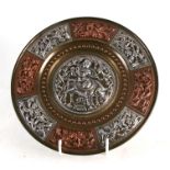 An Indian plaque with silver and copper overlay depicting a central figure playing a flute whilst