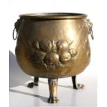 A brass coal or log bin with lion mask handles and embossed decoration, on lion paw feet, 36cms (