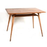 An Ercol blonde elm dining table with rounded rectangular top above an under-tier on tapering