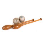 A pair of treen exercise batons or clubs; together with two 1940's Worth Official soft balls (4).
