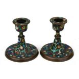 A pair of Chinese copper & enamel candlesticks decorated with scrolling flowers, 8cms (3ins) high.