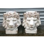 A pair of distressed painted urns in the form of lion heads, each 43cms (17ins) high (2).