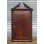 A George III mahogany corner cupboard with single panelled door, 75cms (29.5ins) wide.