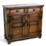 A 17th century style oak cupboard with two frieze drawers above twin carved panelled doors, 98cms (