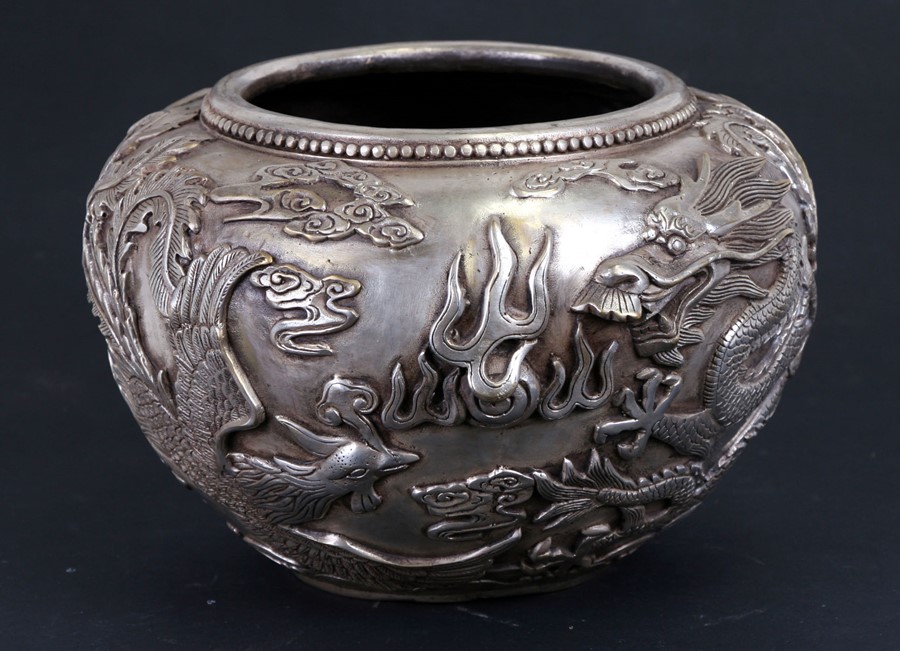 A large Chinese silvered bronze censer decorated in relief with a dragon and phoenix, four character