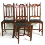 A set of four Arts & Crafts oak dining chairs with pierced back splats, drop-in seats and tapering