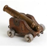 An early 20th century Signal Cannon with brass or bronze barrel mounted on a wood and brass