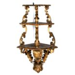 A gilt carved wood three-tier corner shelf in the rococo style, 38cms (15ins) wide, (a/f);