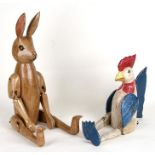 A carved wooden articulated model of a rabbit, approx 65cms (25ins) high; together with a similar