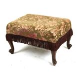 A rectangular upholstered foot stool on cabriole legs, 65cms (25.5ins) wide.