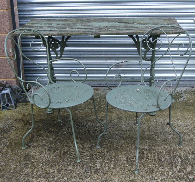 A painted cast iron garden table with wooden slatted top, 138cms (54ins) wide; together with two