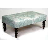 A George III style upholstered foot stool on turned legs, 95cms (37.25ins) wide.