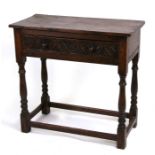 A 17th century style oak side table with single frieze drawer having carved decoration, on turned