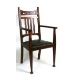 An Arts & Crafts oak carver chair with pierced back rail, drop-in seat and square tapering legs with