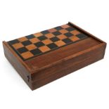 A Backgammon set with leather beakers and boxwood pieces, in an oak case inlaid with a chess
