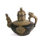 A large Tibetan kettle with brass mounts, dragon handle, mythical beast spout and pottery body,