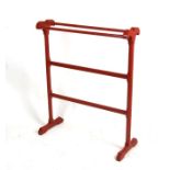 A Victorian red painted towel rail, 72cms (28ins) wide.