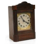 An oak mantle clock, the silvered dial with Roman numerals, fitted with a movement striking on a