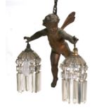 A gilt spelter ceiling light in the form of a cherub with prismatic glass drops.Condition