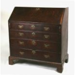 A 19th century oak bureau with a fall front revealing a fitted interior above four long graduated