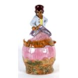 A majolica pottery biscuit jar and cover depicting a young boy holding a pipe seated on a hay stack,