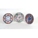 A Japanese famille rose plate; together with two Japanese Imari plates, the largest 22cms (8.6ins)